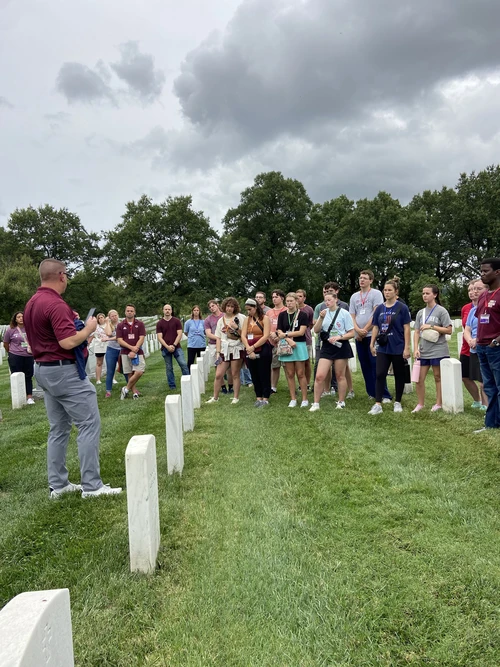 Brigadier General James Schreffler, vice president for patriotic activities, shares with the students about those who served in Operation Enduring Freedom and Operation Iraqi Freedom in Section 60 of the Arlington National Cemetery. 
